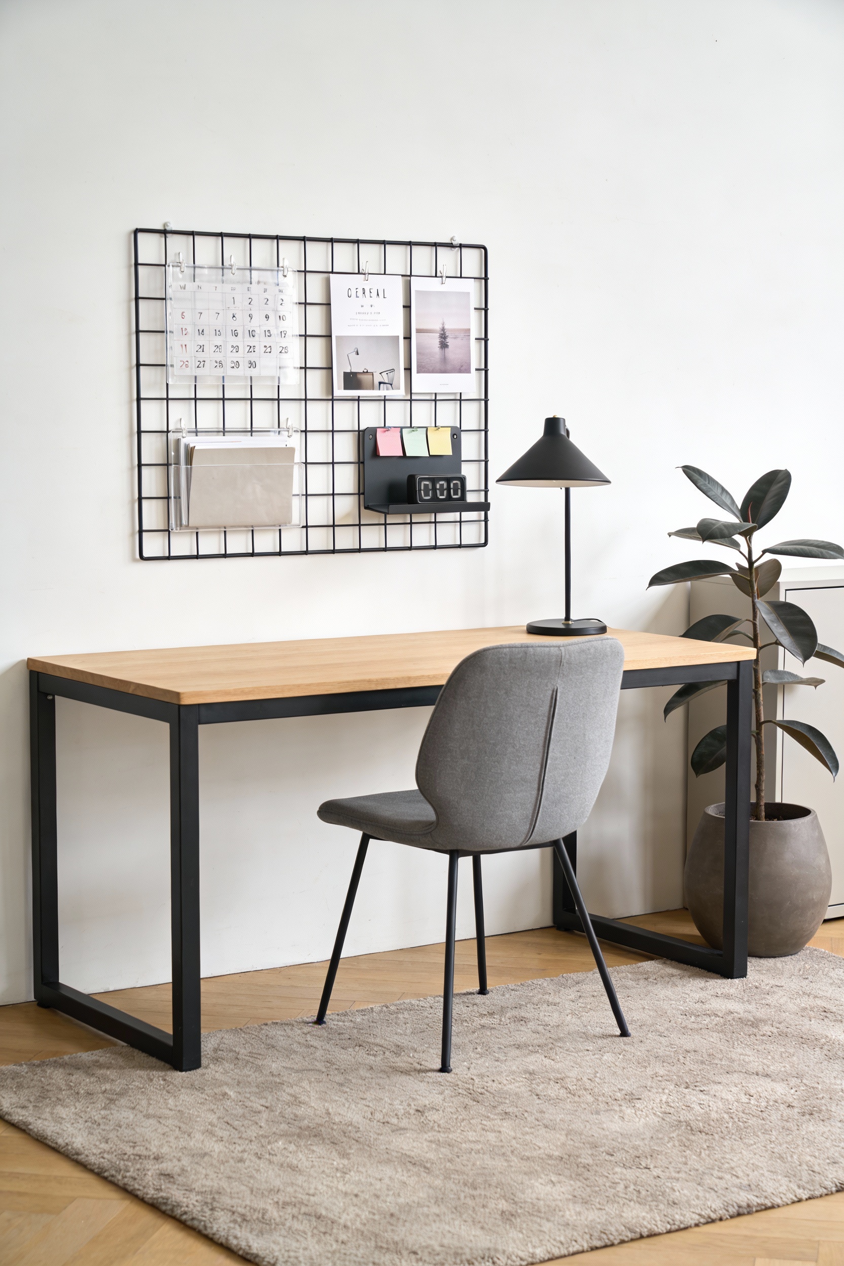 Straight-on medium shot of a modern minimalist home office wall: white and charcoal palette with warm wood; black metal 