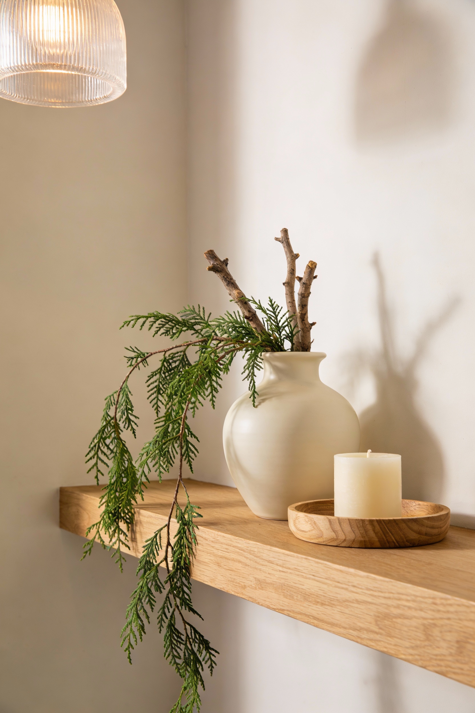Detail close-up photorealistic shot of Scandinavian hallway styling on a light oak floating shelf/console against creamy